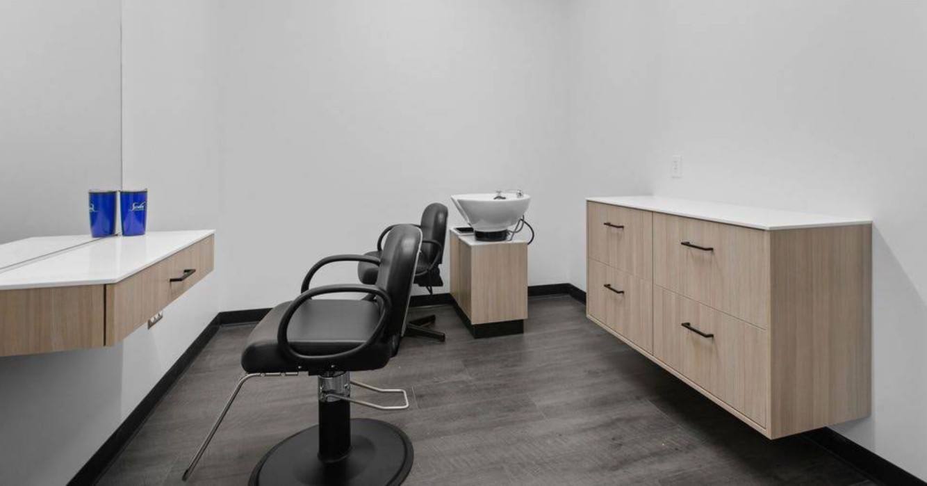 Minimalist private studio with styling chair and wood cabinetry