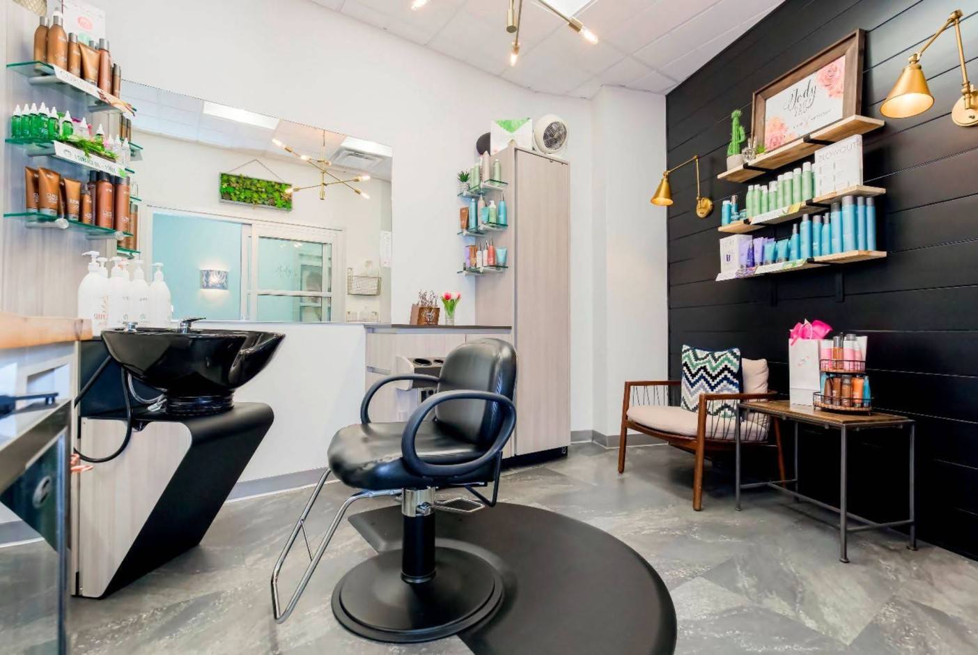 Colorful, plant-filled private salon studio with black shampoo bowl